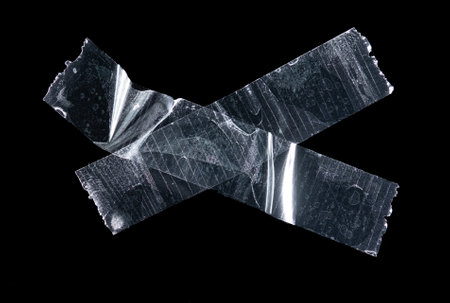 Transparent adhesive plastic tape pieces isolated on black background,Crumpled glue plastic sticky tapeの写真素材