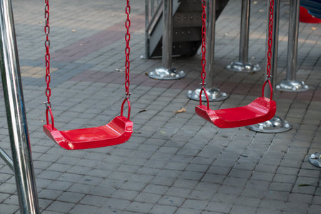 Red chain swings on modern kids playgroundの写真素材