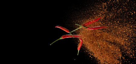 Red pepper powder explosion isolated on black background,Flying red pepper,Motion blurの写真素材