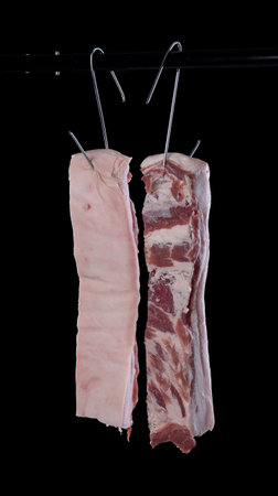Belly pork meat hanging from the hook, isolated on white background.の写真素材