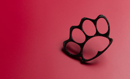 Black brass knuckles on red backgroundの写真素材