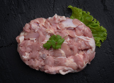 Sliced chicken breast in pieces on marble board. Black backgroundの写真素材