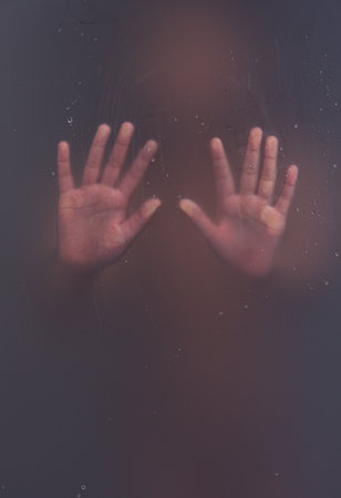 Depressed child concept stuck behind glass seeking helpの写真素材