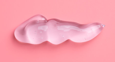 Transparent gel drop on pink background. Liquid gel cosmetic stain texture. Beauty serum drop