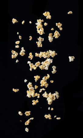 Popcorn bursting in the air over black backgroundの写真素材
