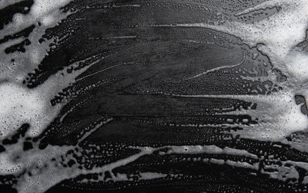 Soap foam, lather  on black, texture and background, top viewの写真素材