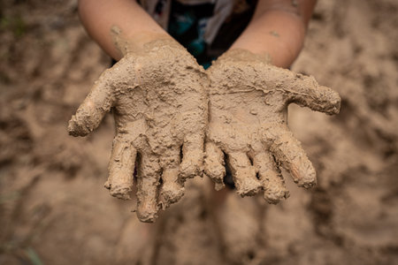 Mud on a child's hands. Children's plays with natural materialsの写真素材
