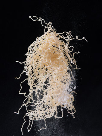 Raw noodles splash or explosion flying in the air over dark backgroundの写真素材