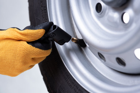 driver checking air pressure and filling air in the tires close upの写真素材