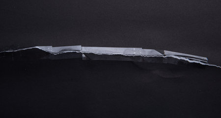 Torn black paper with transparent adhesive tape or strips,repair paperの写真素材