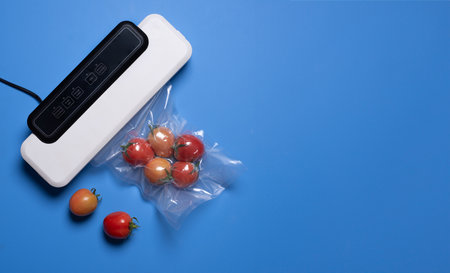 Vacuum seal packing machine with plastic bag of tomatoes in vacuum packed sealed for sous vide cookingの写真素材