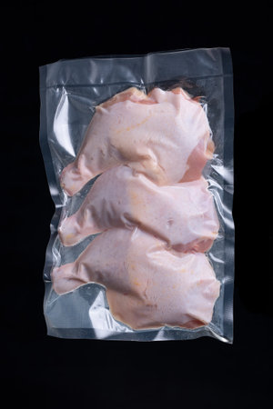 Chicken thighs in vacuum packed sealed for sous vide cooking, on black backgroundの写真素材