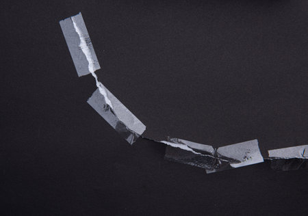 Torn black paper with transparent adhesive tape or strips,repair paperの写真素材