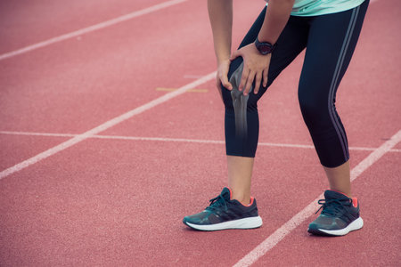 Female runner knee injury and pain,Painful Knee Close-up - Anatomy conceptの写真素材