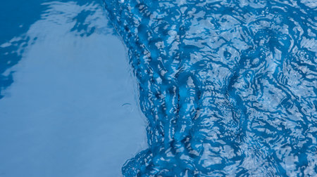 Closeupâ blurâ abstractâ ofâ surfaceâ blueâ water. Abstractâ ofâ surfaceâ blueâ waterâ reflectedâ withâ sunlightâ forâ background.Topâ viewâ of blueâ waterの写真素材