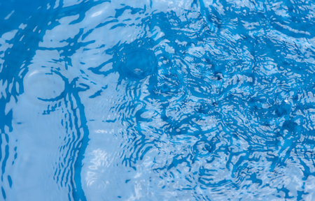 Closeupâ blurâ abstractâ ofâ surfaceâ blueâ water. Abstractâ ofâ surfaceâ blueâ waterâ reflectedâ withâ sunlightâ forâ background.Topâ viewâ of blueâ waterの写真素材