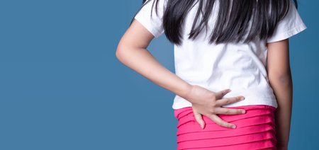Businesswoman with pain in back on blue backgroundの写真素材