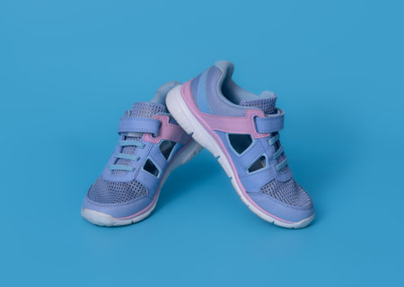 Baby's little blue sneakers on a blue background.の写真素材