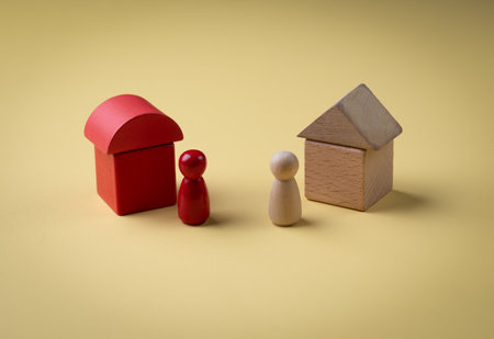 Wood House Model and wooden figurines on yellow background ,Property, hospitality concept using wooden house and human model.の写真素材