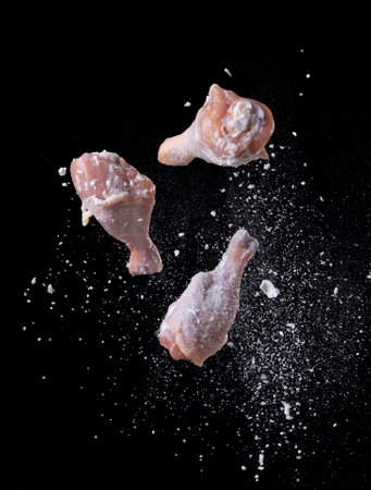 Crispy fried chicken,Flying coating chicken drunsticks with flour isolated on blackの写真素材
