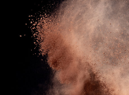 Brick Sand flying explosion,  Abstract cloud fly. Orange colored sand splash throwing in air on black backgroundの写真素材