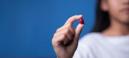 Young girl holding red pill with medicine. Healthcare conceptの写真素材