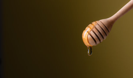 Close-up of honey dipper against yellow backgroundの写真素材