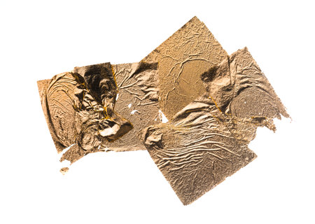 Crumpled gold leaf isolated on a white backgroundの写真素材