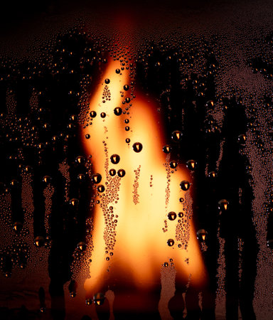 Fire flame with water drops on glass. Abstract backgroundの写真素材