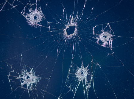 Broken glass bullet holes isolation on blue background,Cracked glass
