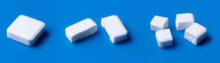 White broken pills lie on a blue background.Pharmacy medicament concept.の写真素材