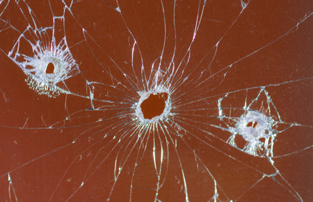 Broken glass bullet holes on orange background,Cracked glassの写真素材