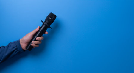 holding a microphone with copy space against blue background, interview concept.の写真素材