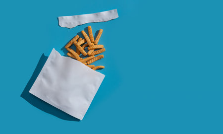 Open packages and crispy snacks on blue backgroundの写真素材
