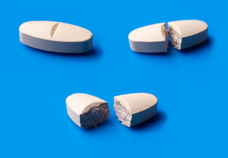 White broken pills lie on a blue background.Pharmacy medicament concept.の写真素材