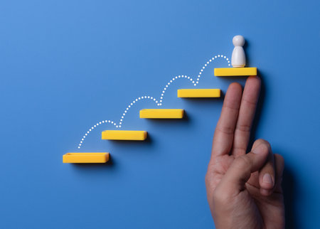 Wooden people figures on top of wooden blocks Career growth, Business Development and leadership conceptの写真素材