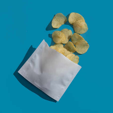 Potato chips in plastic bag on blue background,の写真素材