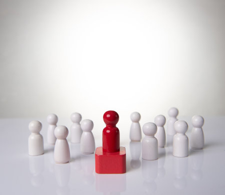 Leadership concept - red wooden figure leading other wooden figures reaching. Leadership conceptの写真素材