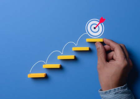 Stairs made by wooden blocks with the target icon at the top. goals concept, achievement or business progress goal concept.の写真素材
