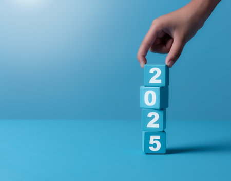 New project growth concept in 2025, Preparation for happy new year , Hand of man flip wooden cube from 2024 to 2025 on blue background, minimal style.の写真素材
