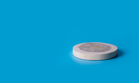Round wooden log cross section on a blue background for Product display and presentation.の写真素材