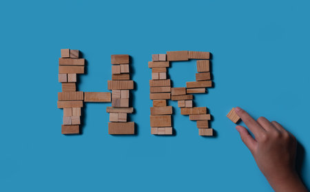 âHRâ word made of wooden blocks on blue background, top viewの写真素材