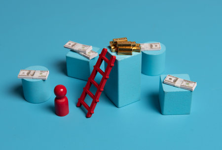Red wooden figures with stairs and gold bars on blue background. Concept of financial goalsの写真素材