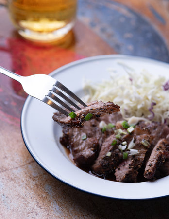 Isaan-style grilled beef, served with a side of fresh herbs and spicyの写真素材