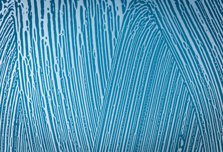 soap foam on window glass, blue background, spring cleaning, abstract patternの写真素材