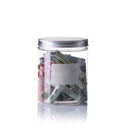 Banknotes in jar isolated with white backgroundの写真素材