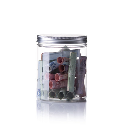 Banknotes in jar isolated with white backgroundの写真素材