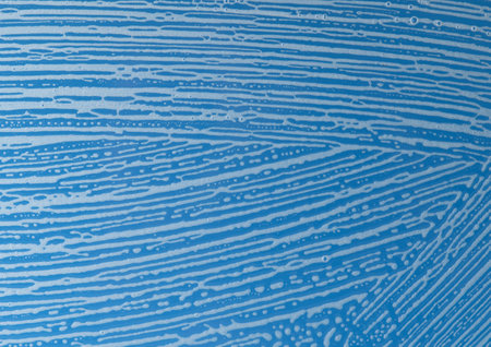 soap foam on window glass, blue background, spring cleaning, abstract pattern