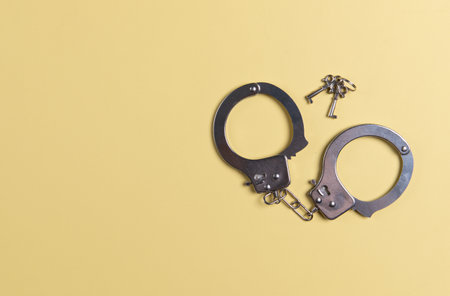 Handcuffs and Keys on a yellow backgroundの写真素材