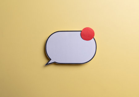 White speech bubble with envelope and red notification badge on yellow background. Concept of new message alert, email communication,の写真素材